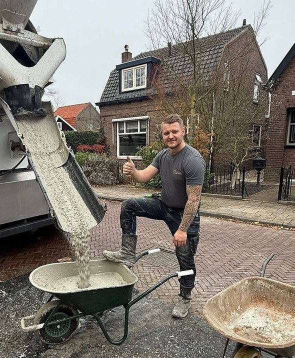 Bouwbedrijf A.W. Verberg aan het werk: beton wordt uit de betonmixer in een kruiwagen gestort