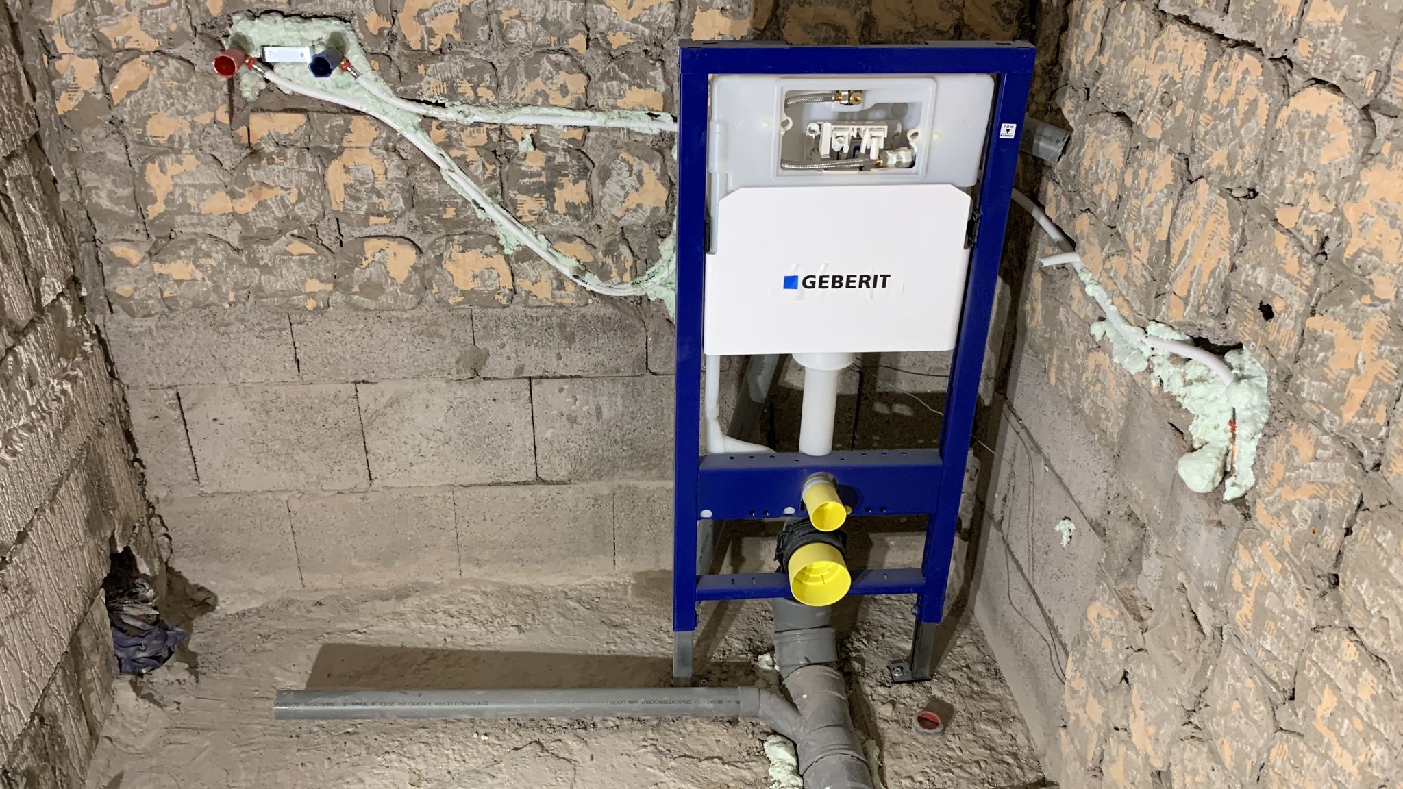 Inbouwreservoir voor een toilet geplaatst tegen een gestripte muur