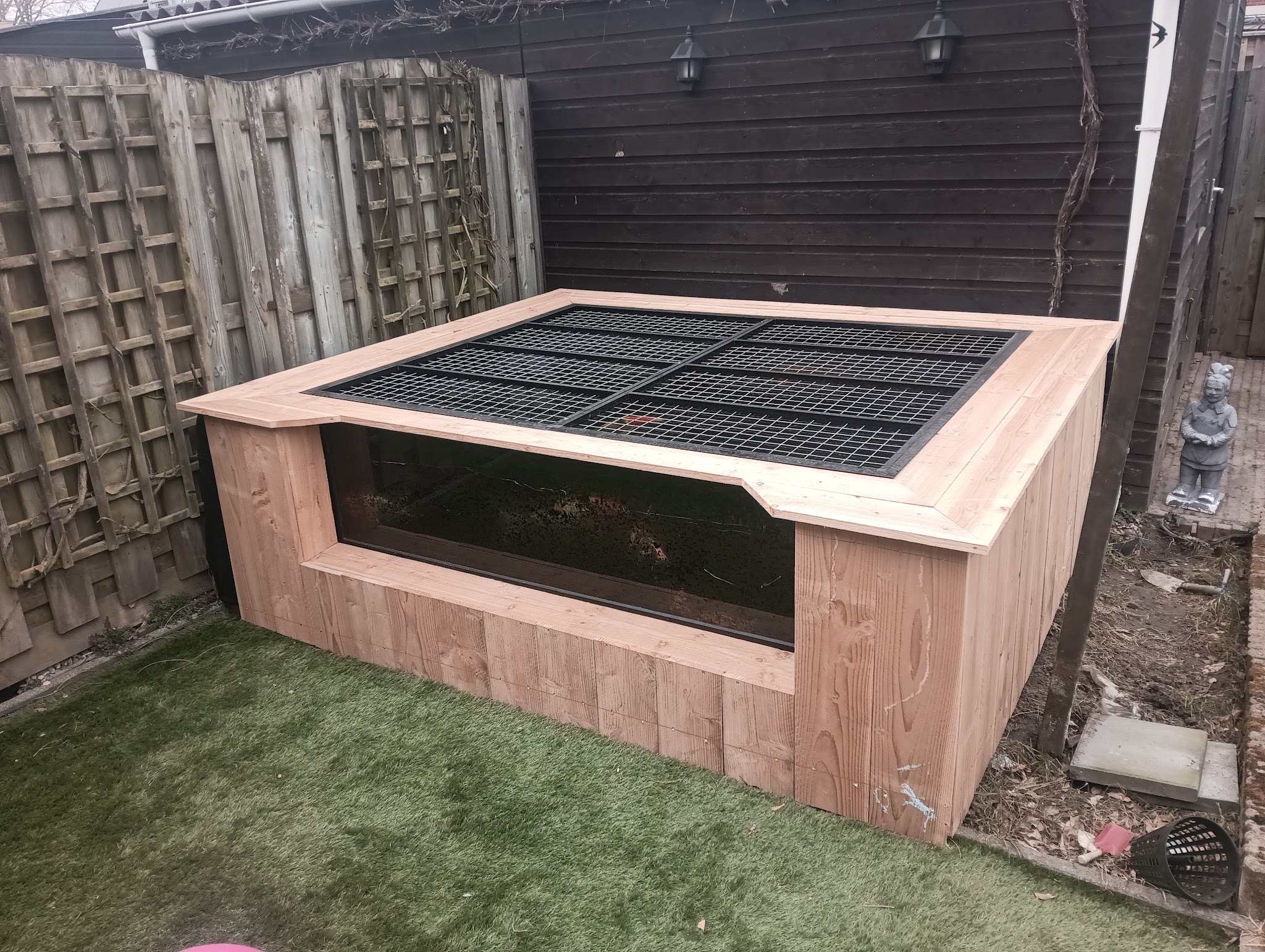 Houten ombouw met glazen zijwand in een achtertuin